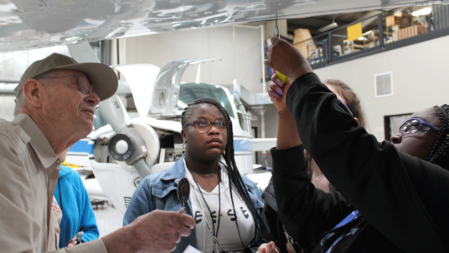 Wings of Hope staff working with students on an airplane.